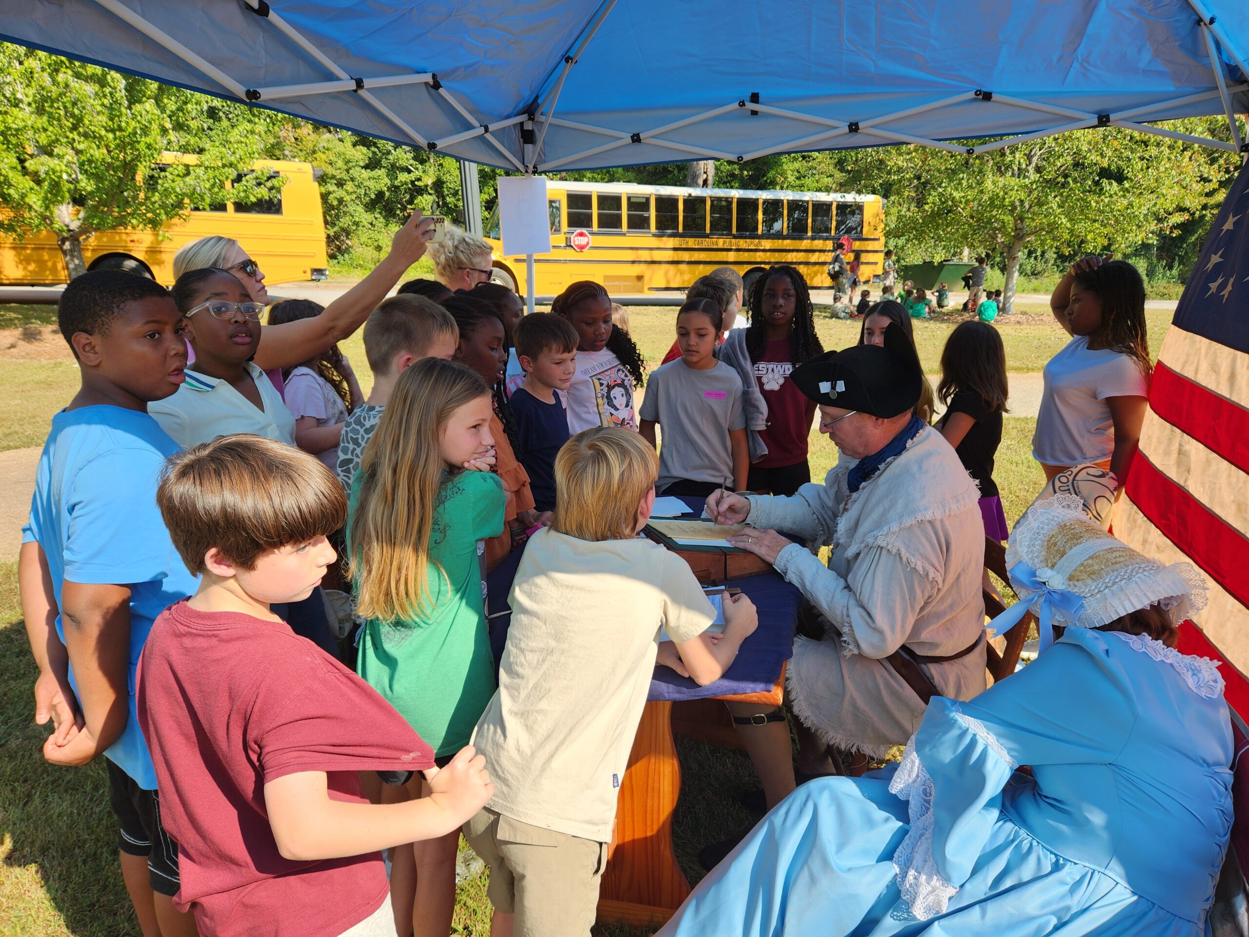 Students participating in Revolutionary War enlistment and musket drill activities